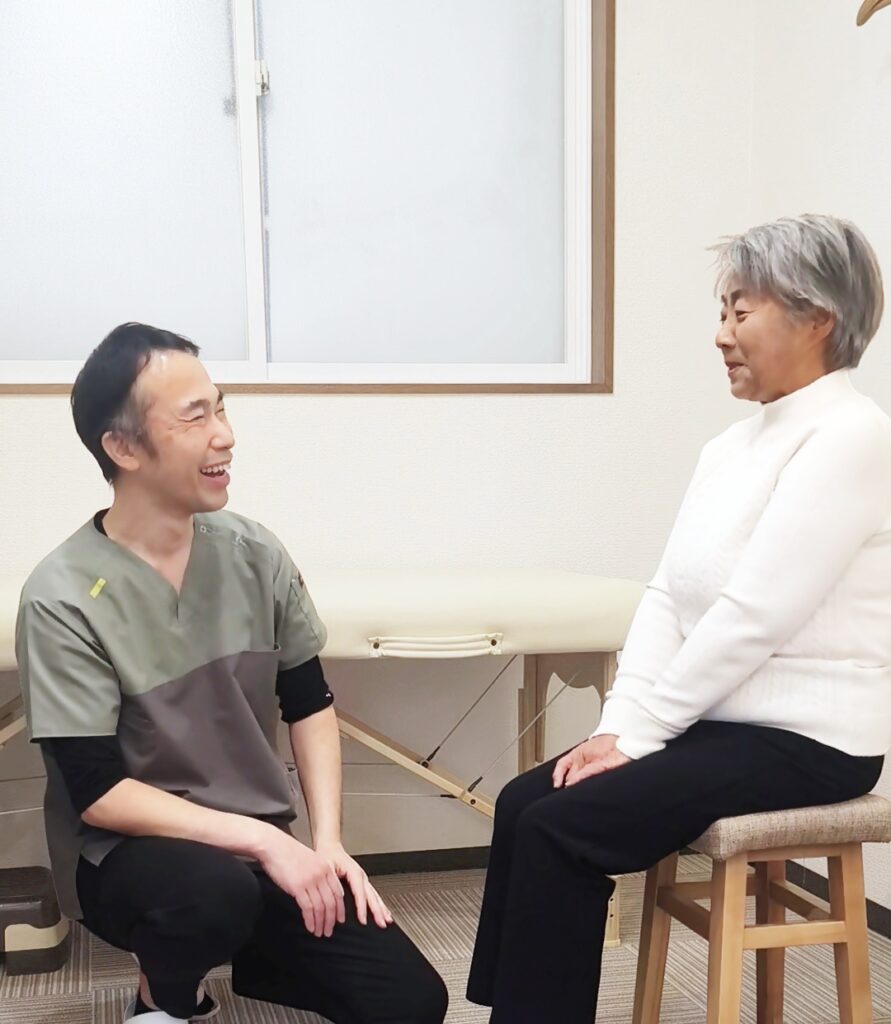 朝起きると腰が痛い症状についてカウンセリングを行う整体師