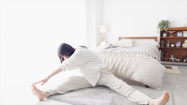 朝起きると腰が痛い人が、起床後に無理のない範囲で行う軽いストレッチの様子
