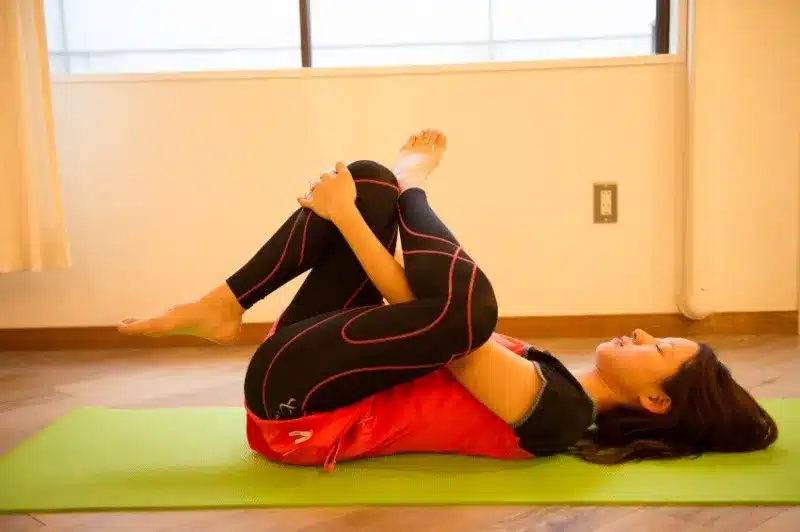 仰向けで片脚を組み、お尻(梨状筋)を伸ばしているストレッチ