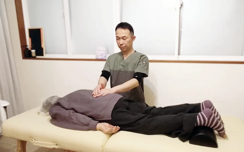 朝起きると腰が痛い症状に対する整体施術の様子
