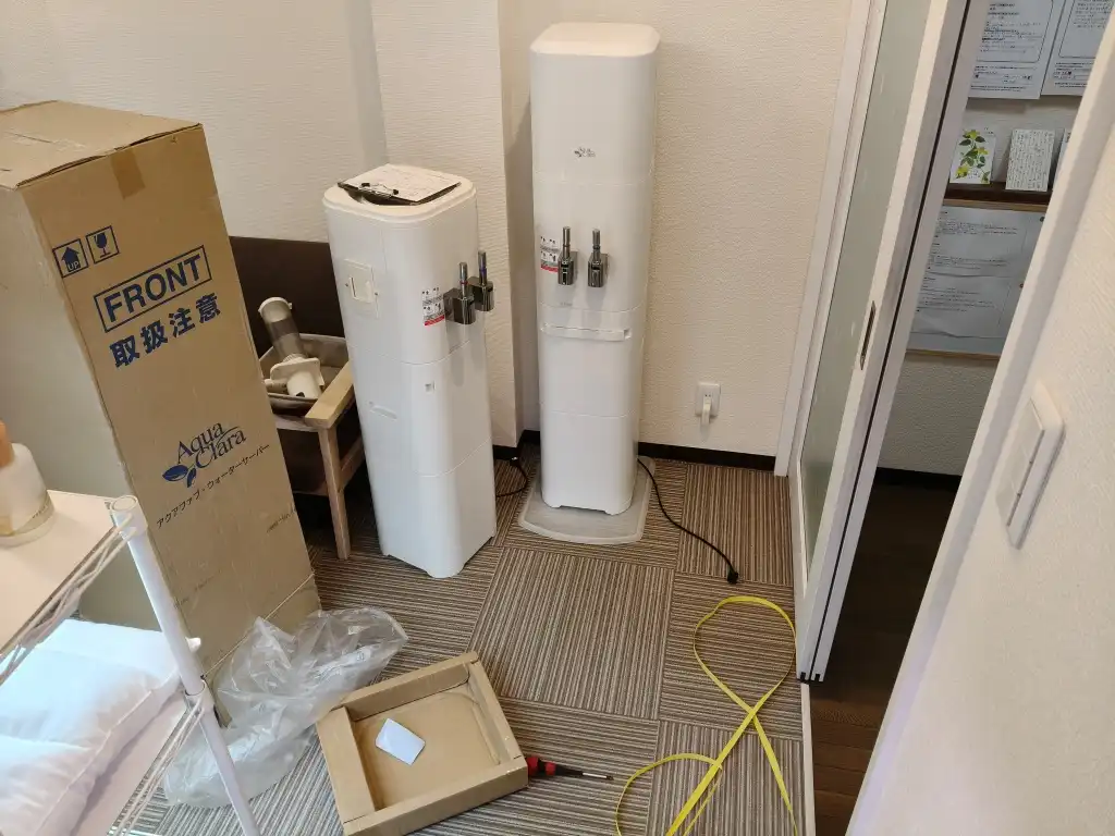 整体院でウォーターサーバーの交換作業をしている様子 メンテナンス中の院内